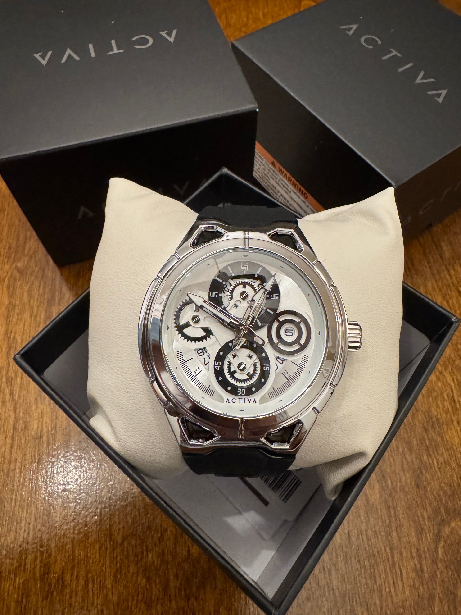 Luxury watch in a black box with 'Activa' branding on a wooden surface