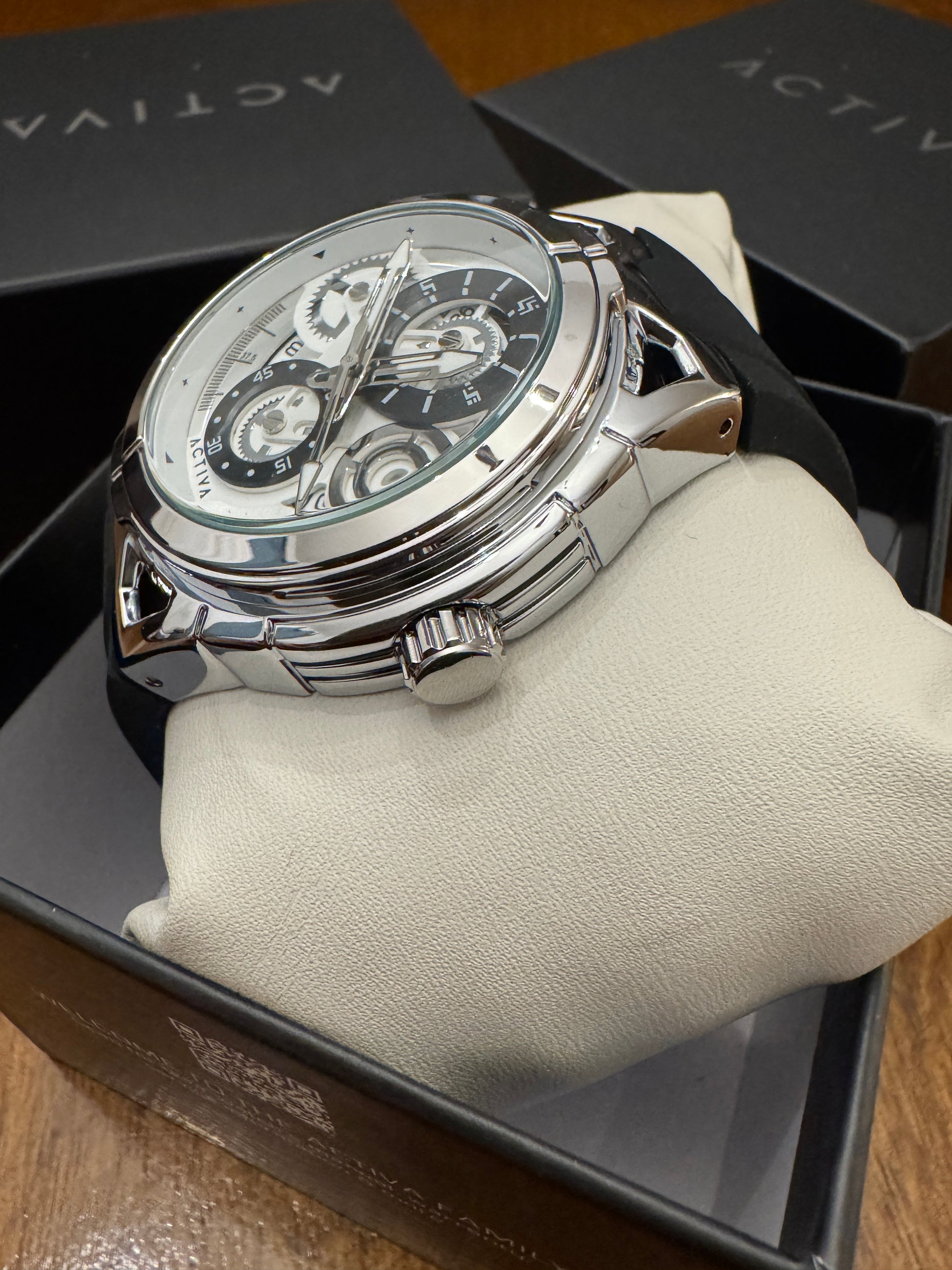 Silver watch on a white cushion with 'Activa' branding in the background